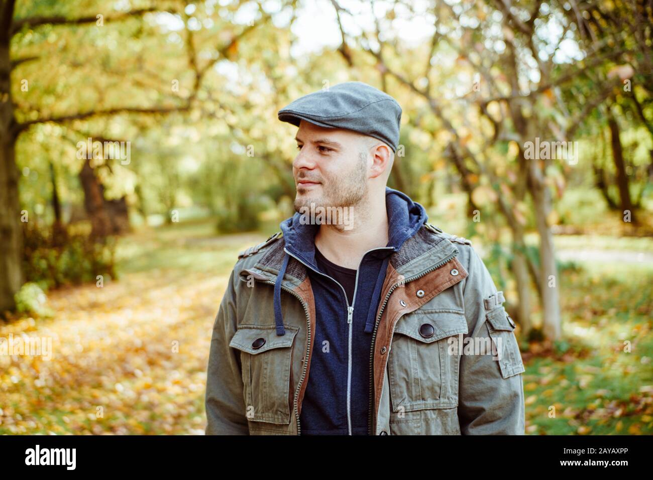 Mann, der in einem Herbstwald oder Park steht. Herbst Stockfoto