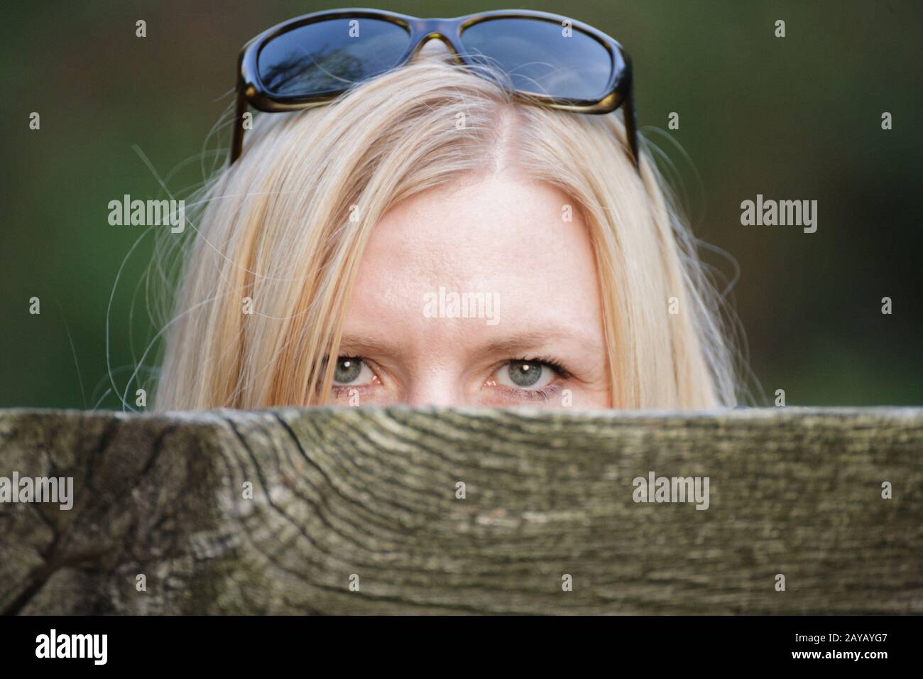 Stalking Frau hinter einem Zaun ihr Gesicht verstecken. Stockfoto