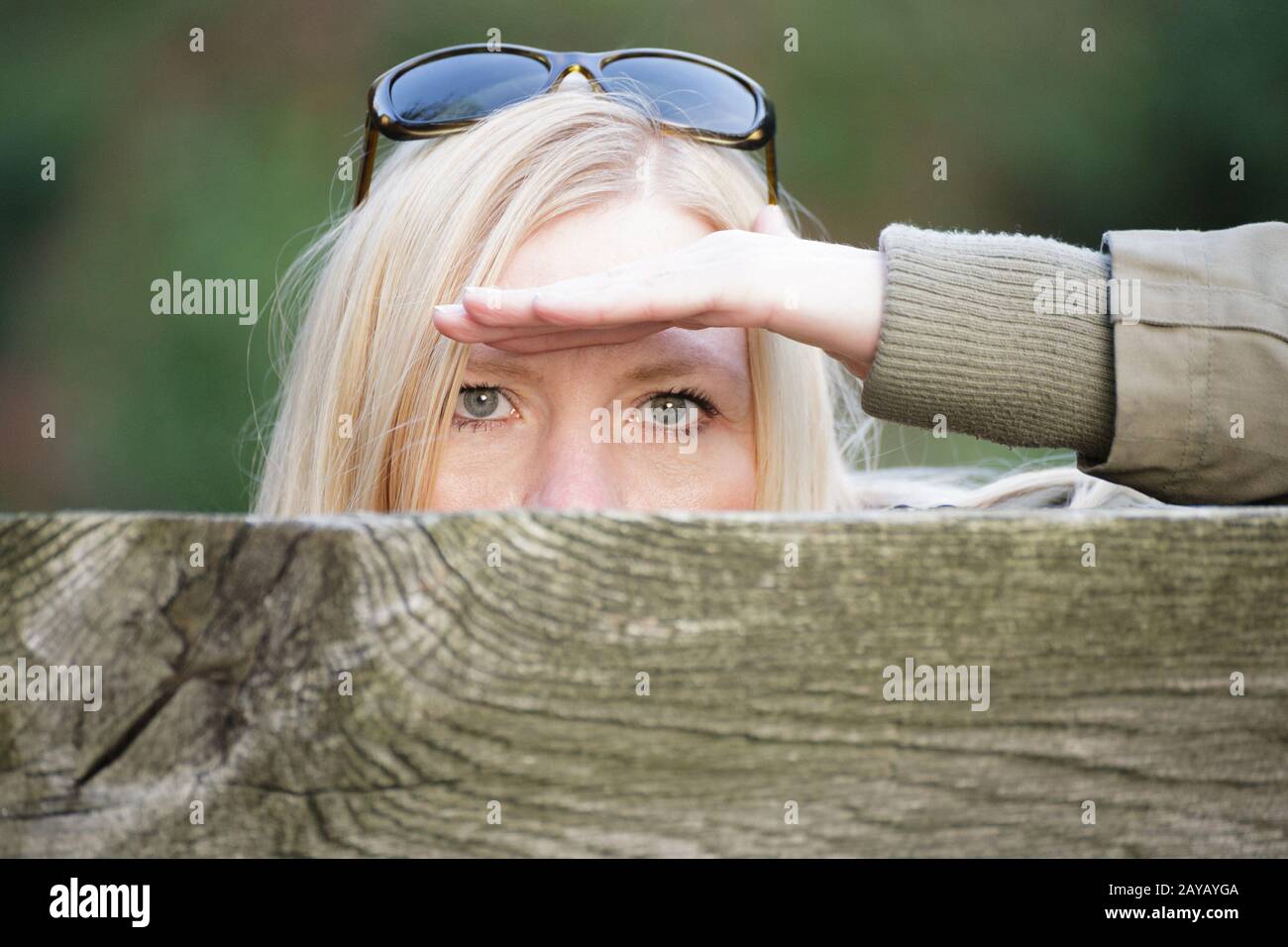 Stalking Frau hinter einem Zaun ihr Gesicht verstecken. Stockfoto