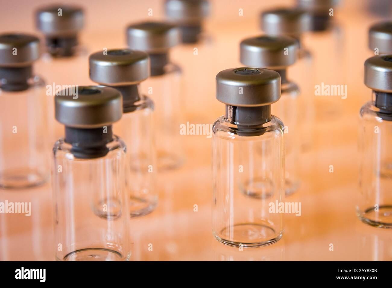 Vakzine Glasflaschen auf orangefarbenem Hintergrund Stockfoto