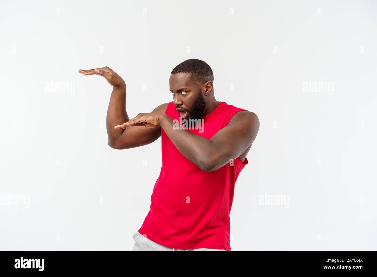 Witzig und verspielt nach African American guy Standing im Profil in der Kampfkunst pose mit angehobenen Palmen, runzelte die Stirn und starrte. Stockfoto