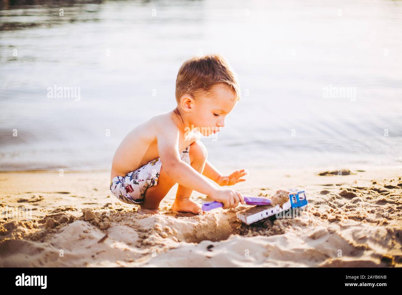 Kinder Spielen Am Strand. Sand- Und Wasserspielzeug. LKW-Spielzeugauto mit Sand und Erde. Baugeräte für grüne Umwelt bei der Arbeit, Contra Stockfoto