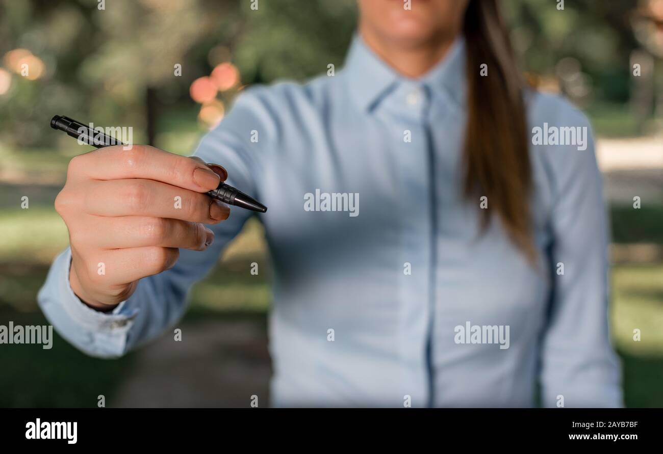 Frau in einem blauen Hemd, die mit dem Finger in den leeren Raum zeigt. Kopierbereich mit Zeigefinger. Geschäftskonzept mit Witz Stockfoto