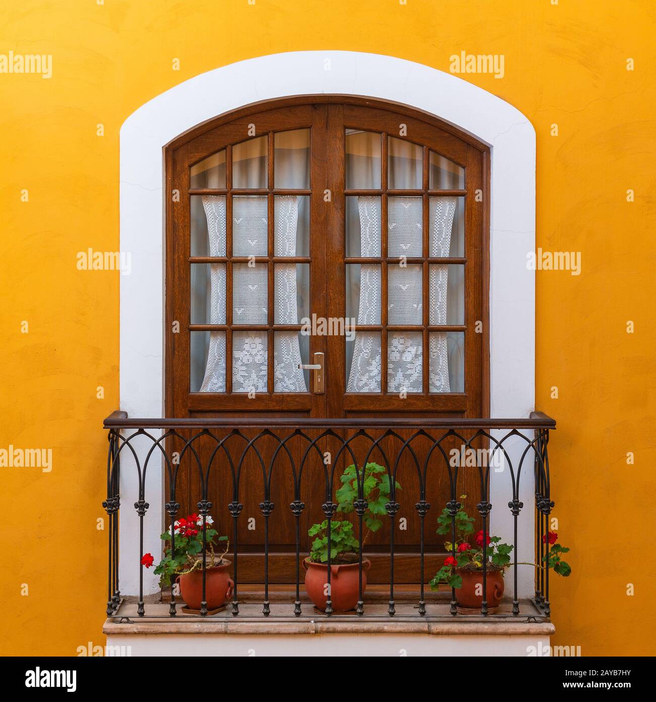 Balkon im Stadtzentrum von Sucre, mit Blumen dekoriert und mit einer gelben Fassade im Kolonialstil, Bolivien. Stockfoto