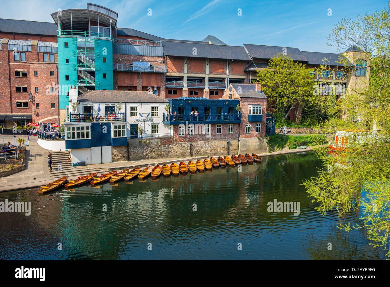 Eine Reihe von vermoorten Ruderbooten am Ufer des Flusses tragen in der Nähe eines Bootsklubs in Durham, Großbritannien an einem schönen Frühlings-Nachmittag Stockfoto
