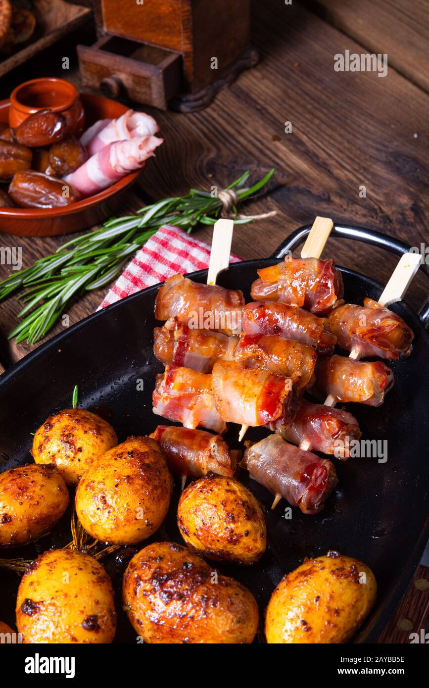 Rustikale Datteln mit Speck und junger gerösteter Kartoffel. Stockfoto