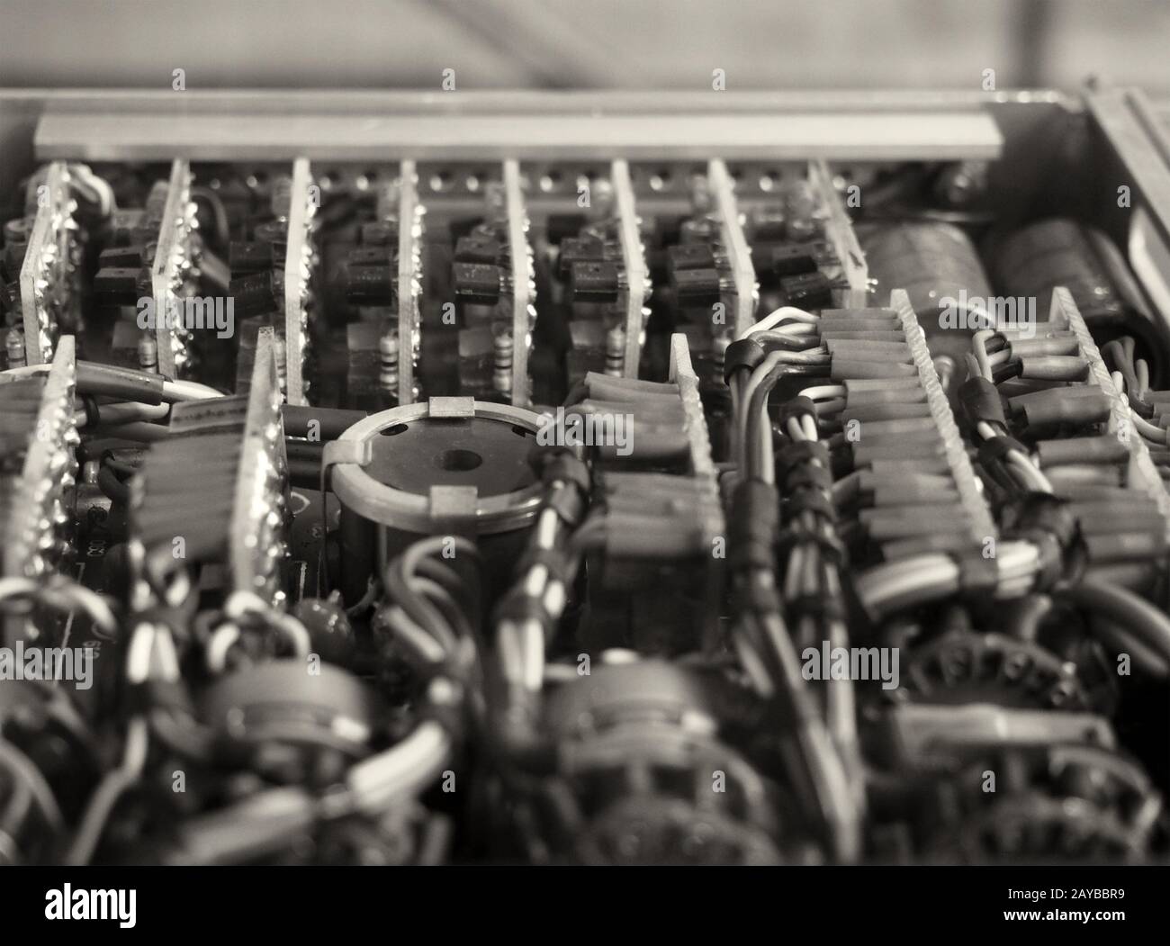 Monochromes selektives Fokusbild komplexer farbiger Verkabelungen und Steckverbinder, die Leiterplatten mit elektrischen Komponenten verbinden Stockfoto