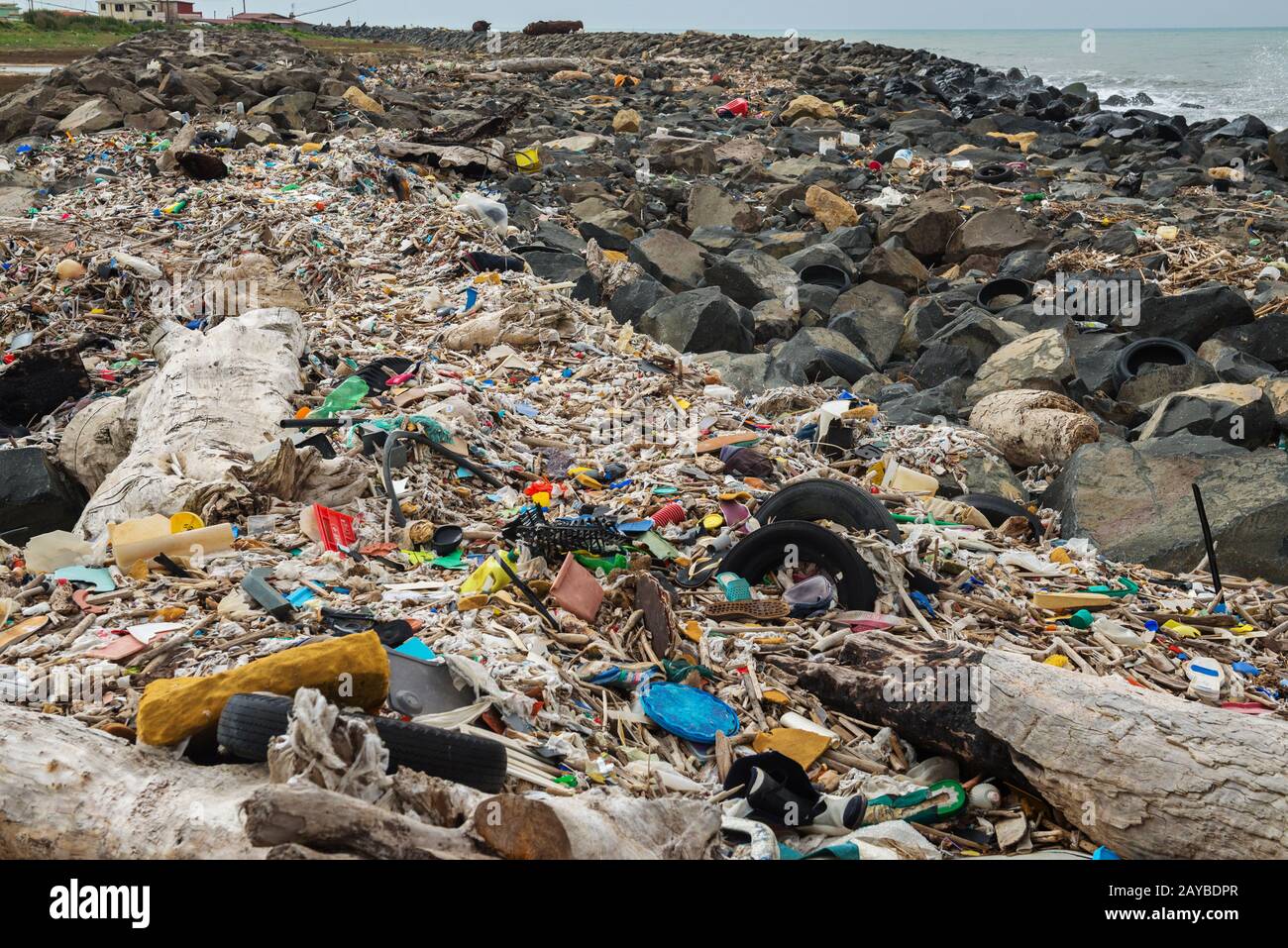 Verschüttete Müll am Strand in der Nähe der großen Stadt. Leere benutzten schmutzige Plastikflaschen und anderen Müll. Stockfoto