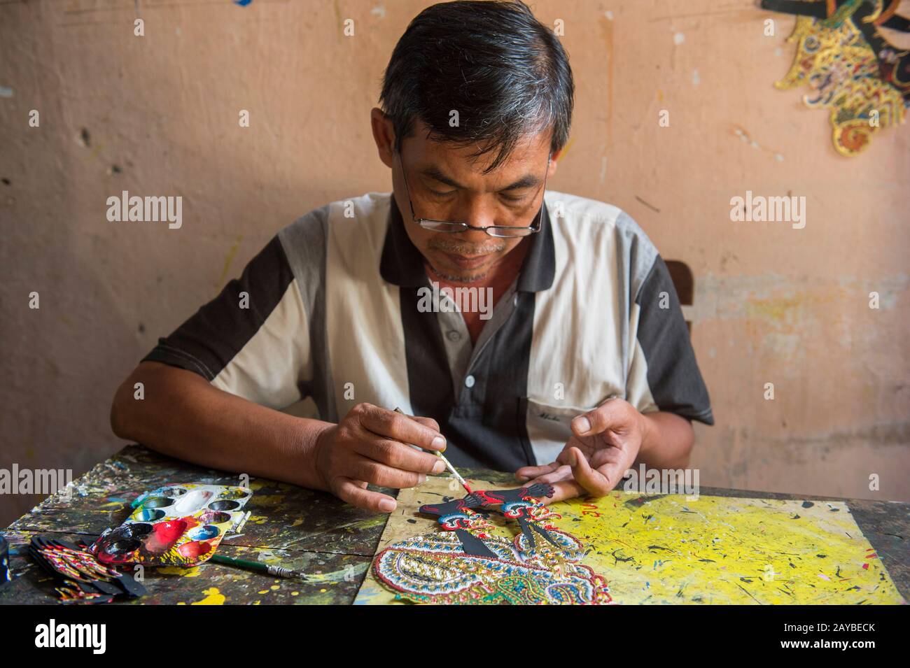 Ein Mann malt traditionellen javanischen Wayang Kulit (Schattenpuppe) aus Leder in Yogyakarta, Java, Indonesien. Stockfoto