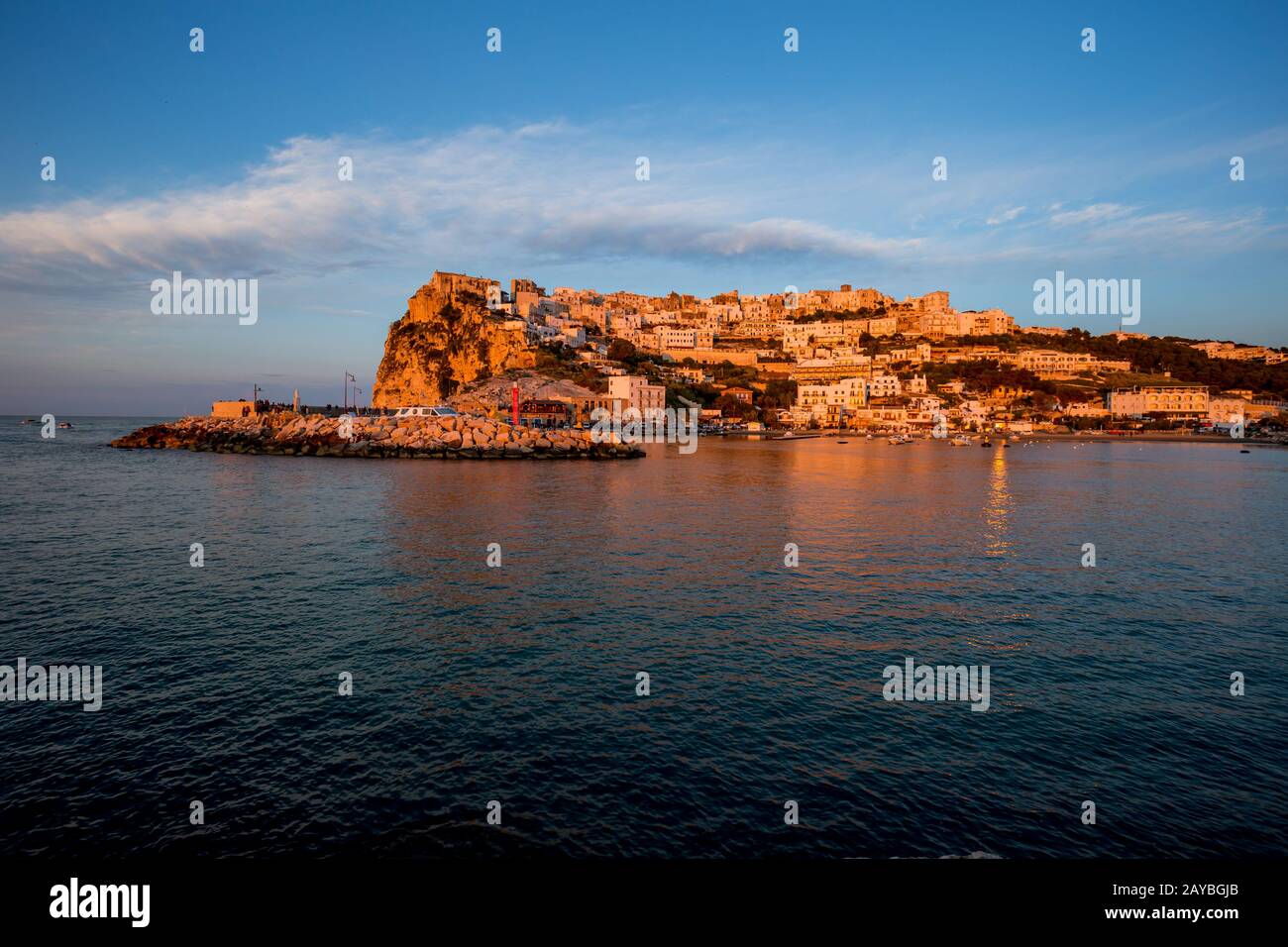 Sonnenuntergang beleuchtete Stadt über dem Meer Stockfoto
