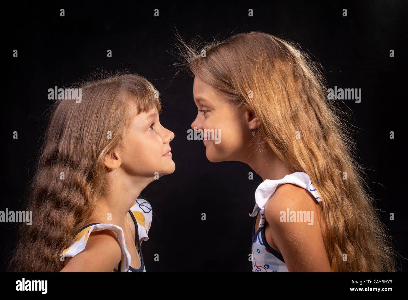 Zwei Mädchen schauen einander von Angesicht zu Angesicht Stockfoto