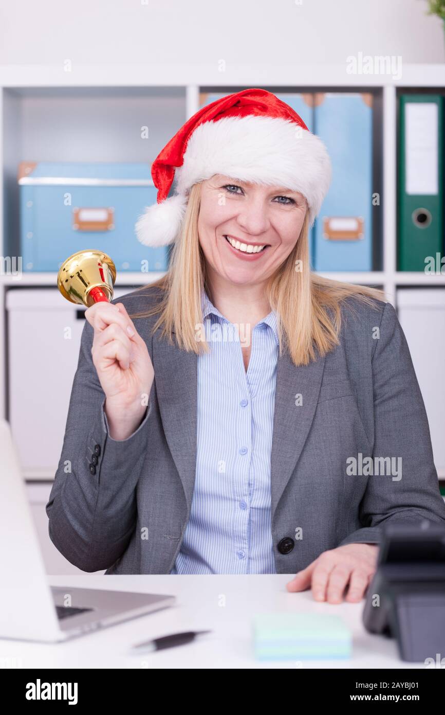 Attraktive Frau läutet zur weihnachtszeit die Glocke. Geschäfts-, weihnachts- und Neujahrsfeier Stockfoto