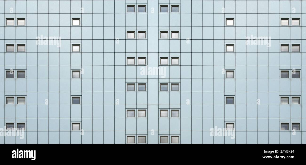 Breite Vollrahmenfassade eines modernen Gebäudes mit geometrischer Metallverkleidung und Linien von sich wiederholenden Musterfenstern Stockfoto