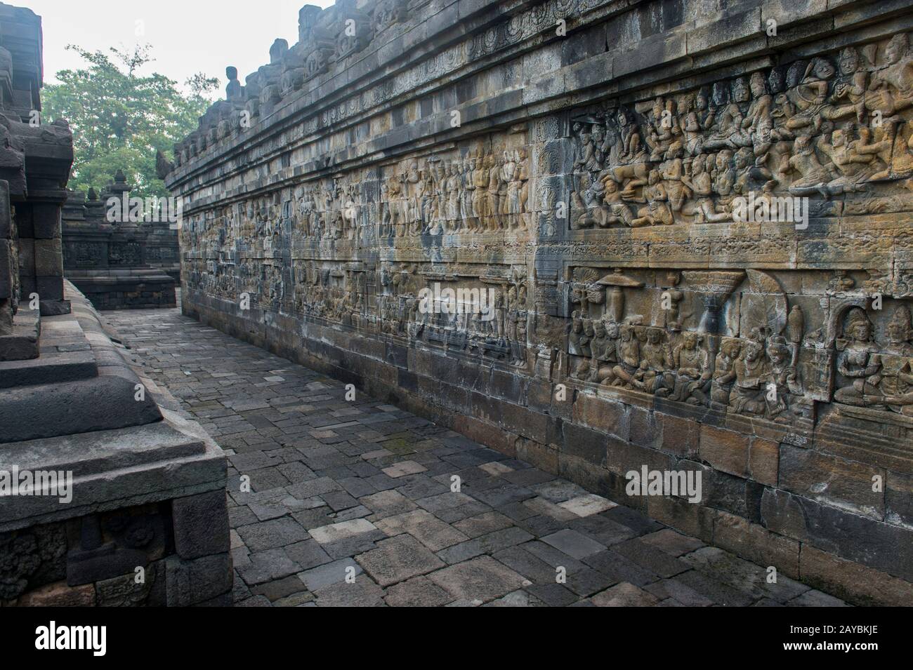 Steinbass-Reliefschnitzereien an einem schmalen Durchgang an einer unteren Plattform des Borobudur-Tempels (UNESCO-Weltkulturerbe, neuntes Jahrhundert), dem größten Budd Stockfoto