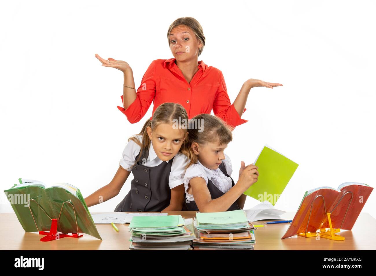 Zwei Mädchen drücken während Sie an einem Schreibtisch sitzen, die Lehrer nicht wissen, was mit ihm zu tun Stockfoto