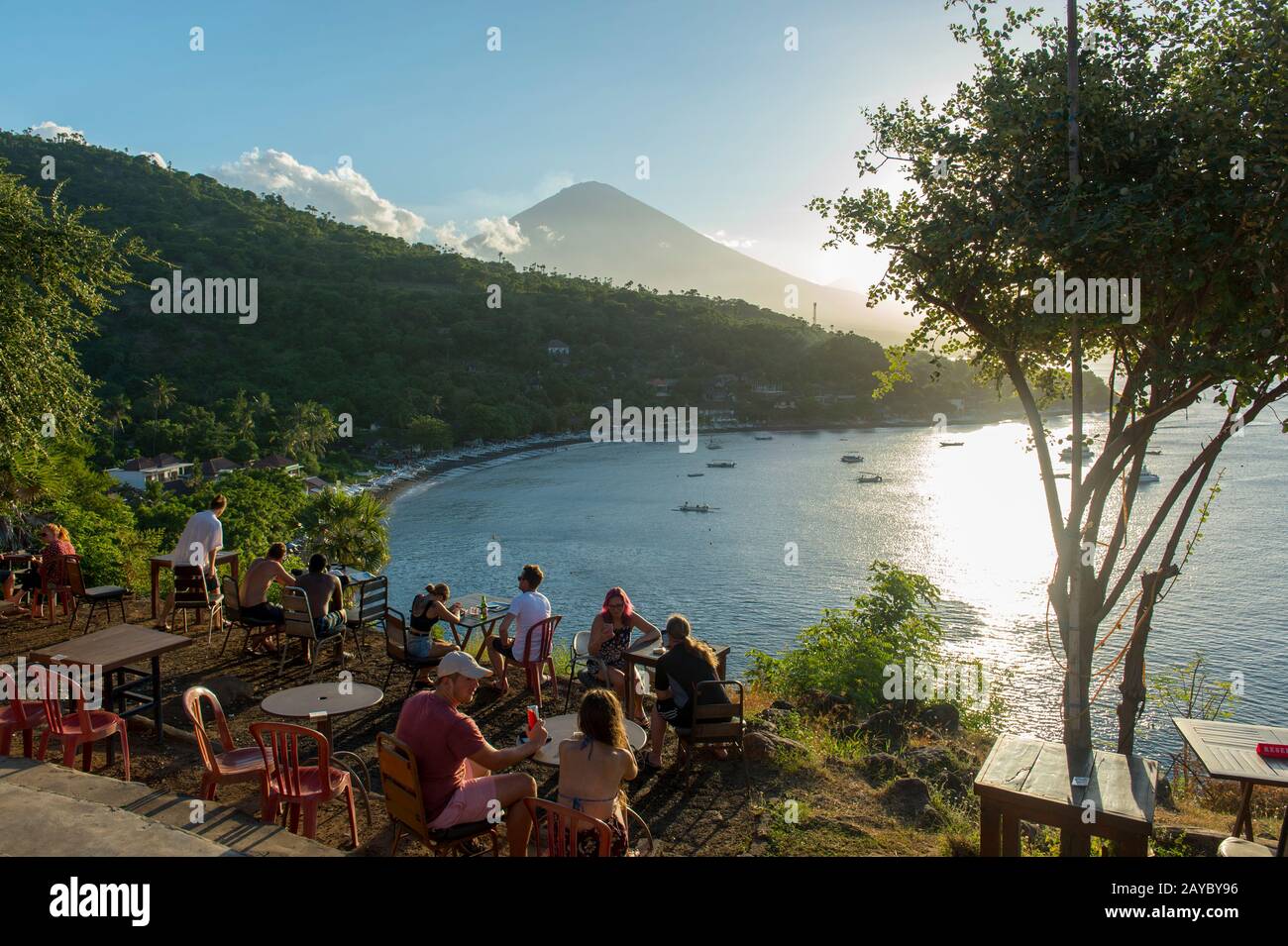 Menschen, die den Sonnenuntergang hinter dem Berg Agung (ein aktiver Vulkan) vom Amed Sunset Point in East Bali, Indonesien, beobachten. Stockfoto