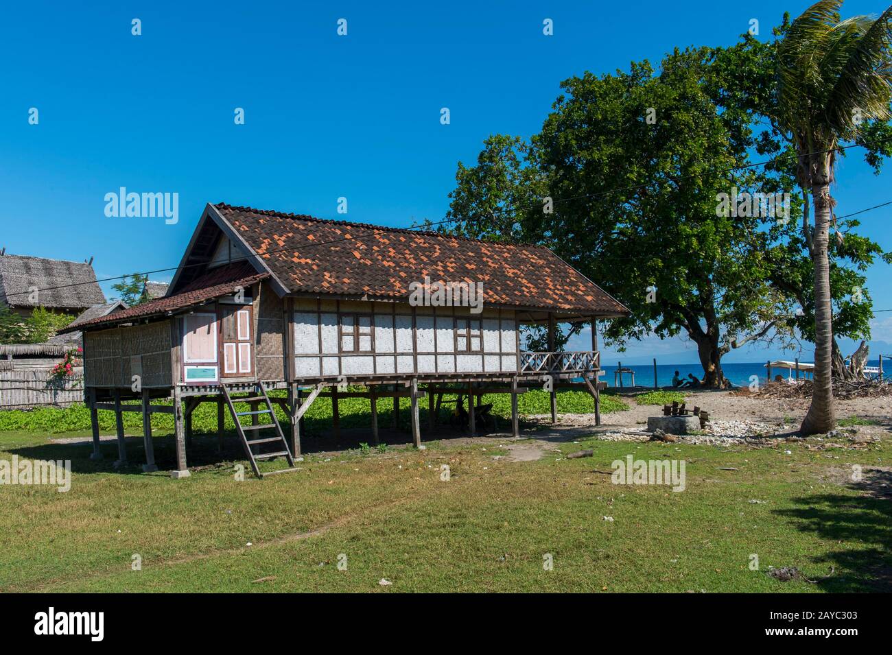 Eine Dorfszene mit einem traditionellen Haus auf Stelzen im kleinen Dorf Moyo Labuon auf Moyo Island, vor der Küste der Insel Sumbawa, Indonesien. Stockfoto