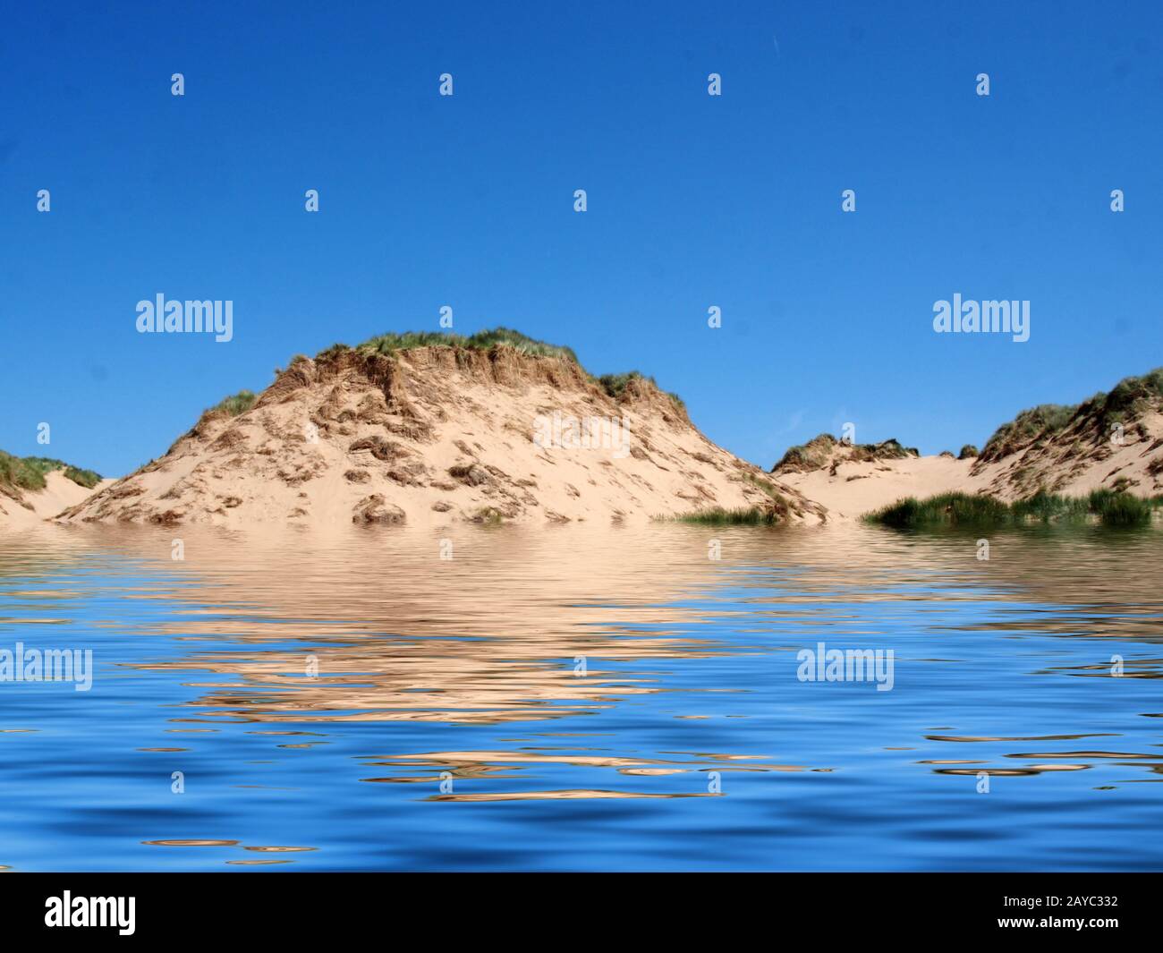 Der Strand vom Meer auf der formby merseyside mit hohen Sanddünen, die mit rauem Gras bedeckt sind, und einem blauen, sommerlichen Sonnenhimmel Stockfoto