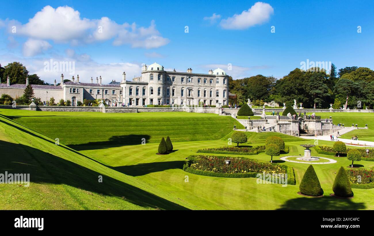 Touristen, die Powerscourt Gardens besuchen, können von einem Hügel aus auf die Villa schauen Stockfoto