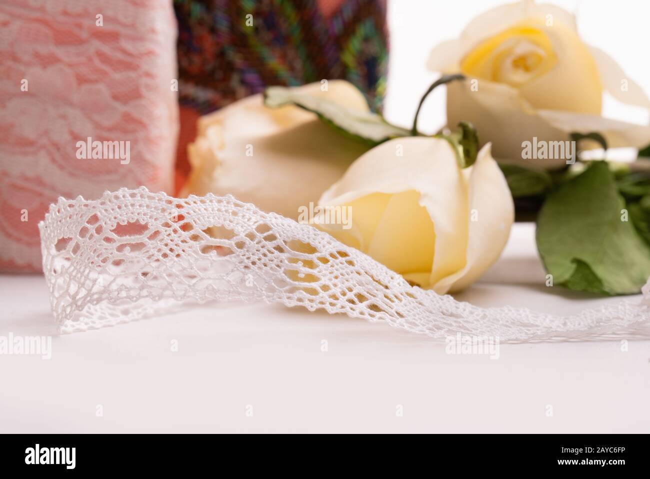 Handarbeit Spitzenband auf dem Tisch unter Rosen Stockfoto