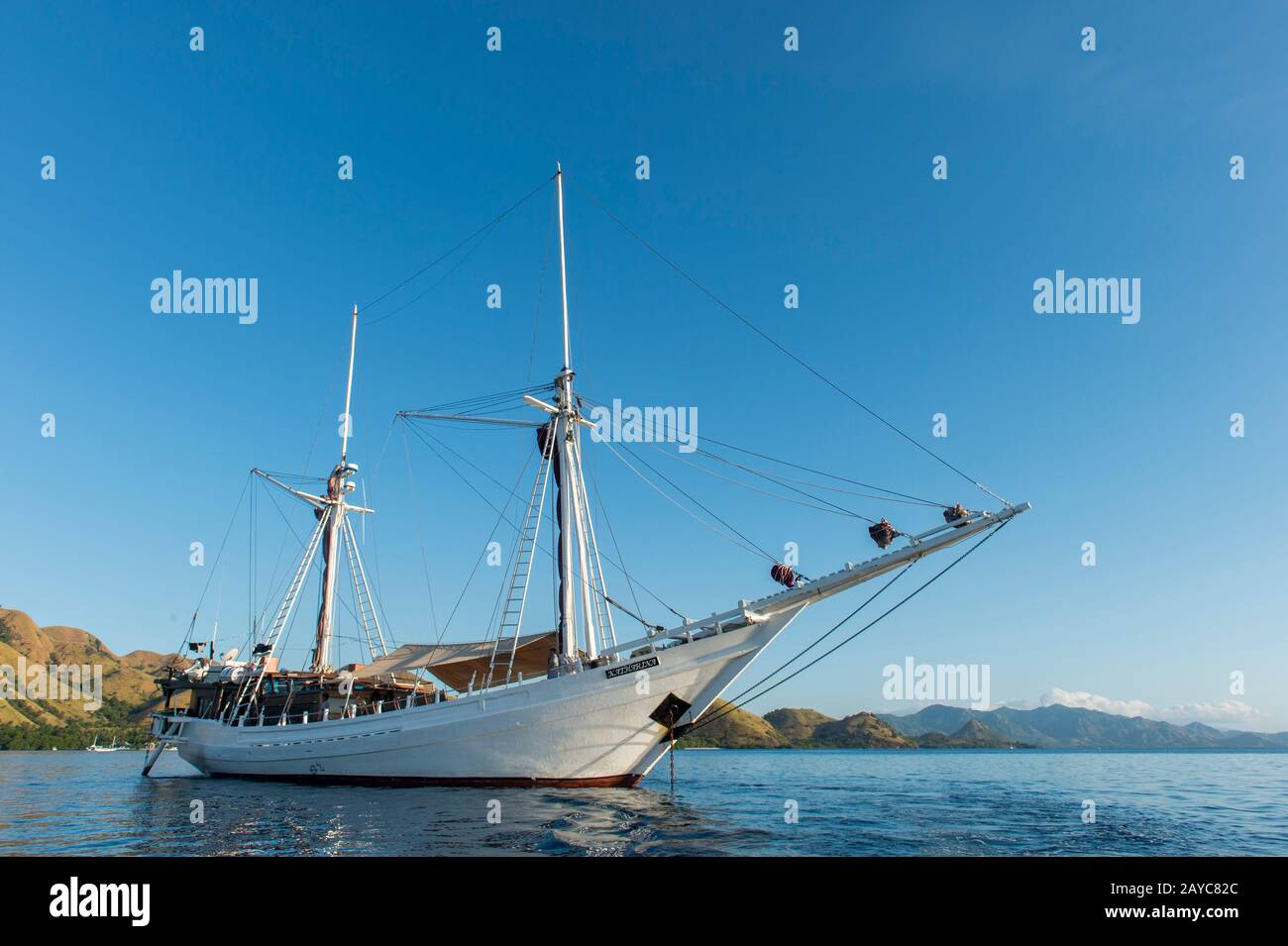 Der MSV Katharina, ein 38 Meter langes Holzpinisi-Schiff (ein traditionelles indonesisches Segelschiff), vor Kelor Island in der Nähe von Komodo Island, Indon vor Anker Stockfoto