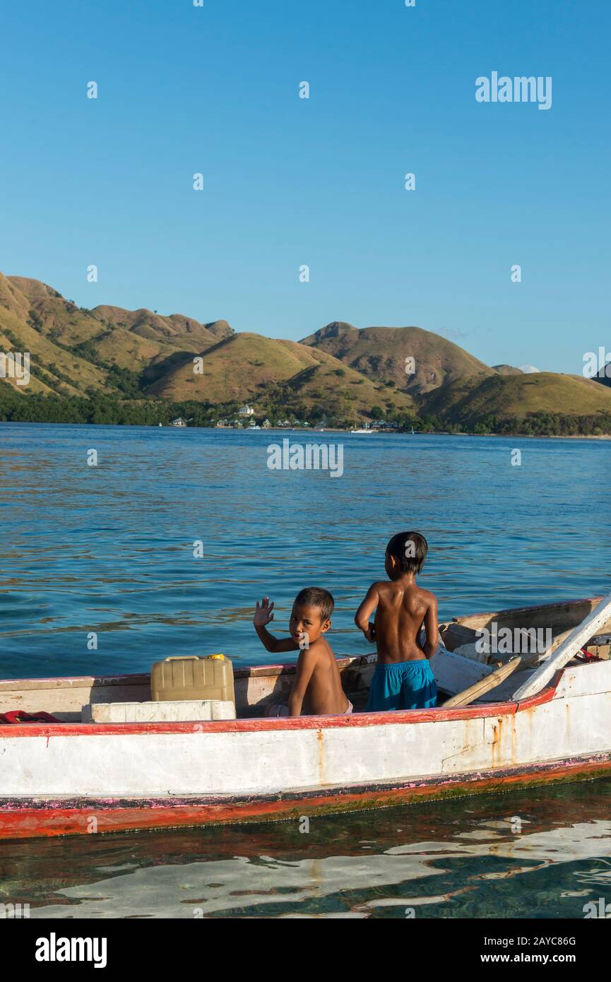 Zwei Jungen, die in einem Holzboot auf der Insel Kelor spielen, einer einsamen Insel, etwa 10 Kilometer von Labuan Bajo, Flores und in der Nähe von Komodo Island, Komodo entfernt Stockfoto