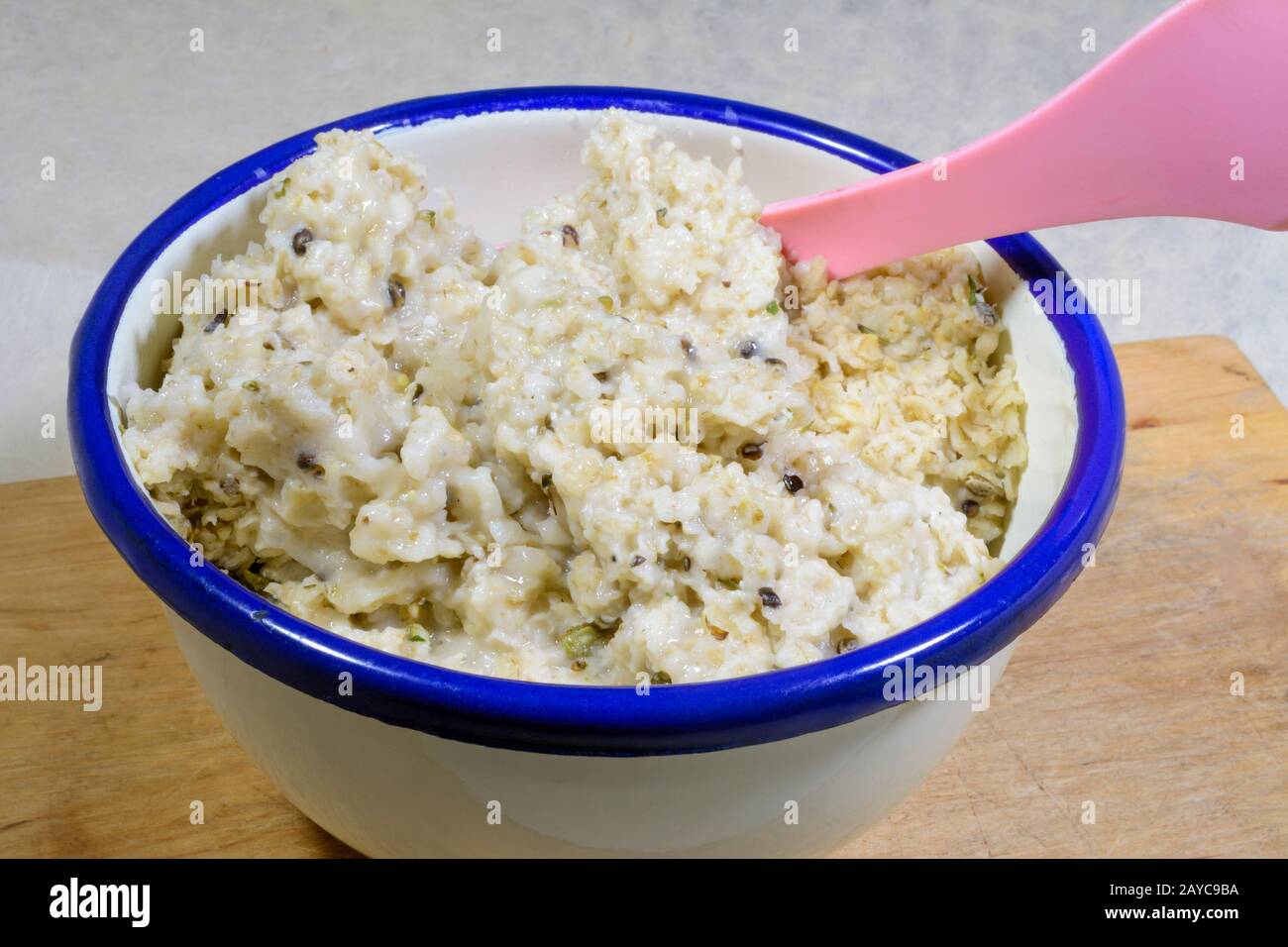 Haferbrei zum Frühstück mit Hempblättern und Samen in einer Emailschüssel Stockfoto