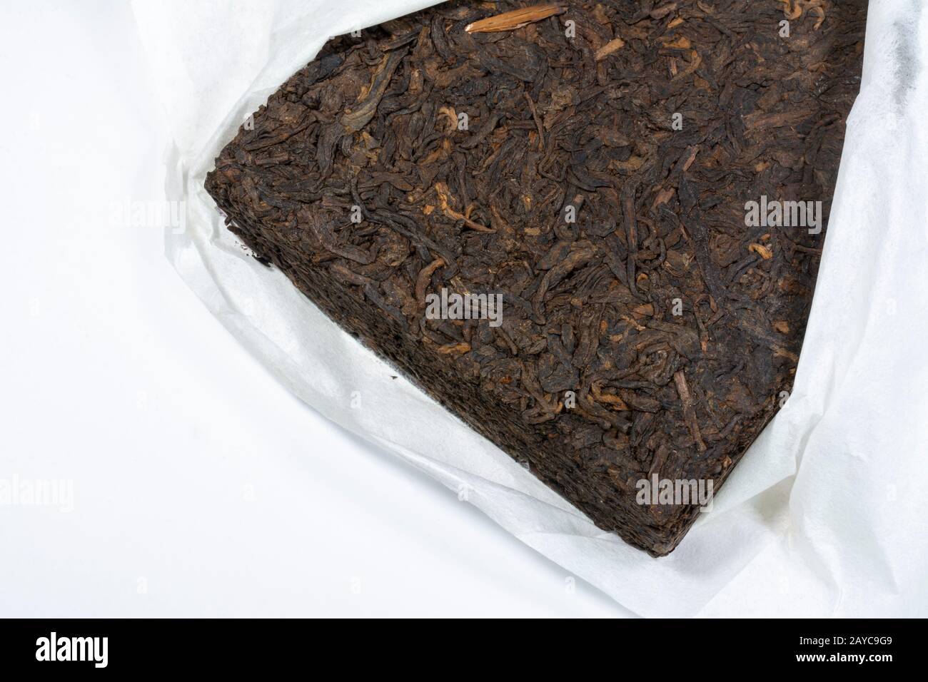 Chinesischer Yunnan Pu Erh Teeblock in weißem Seidenpapier verpackt Stockfoto