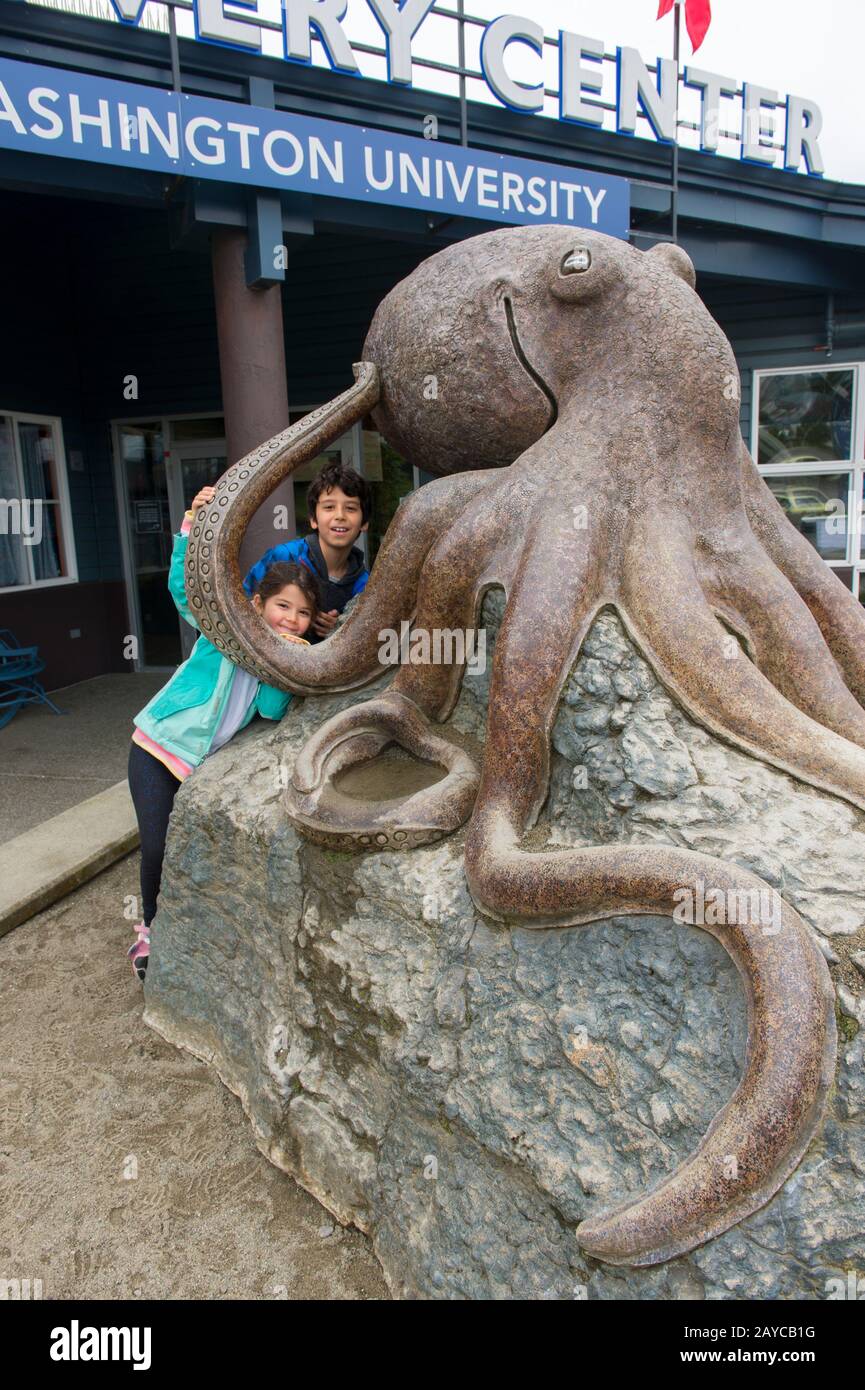 Kinder, die auf die riesige Tintenstatue vor dem SEA Discovery Centre, einem öffentlichen Aquarium, in der Stadt Poulsbo im skandinavischen Stil in Ki klettern Stockfoto