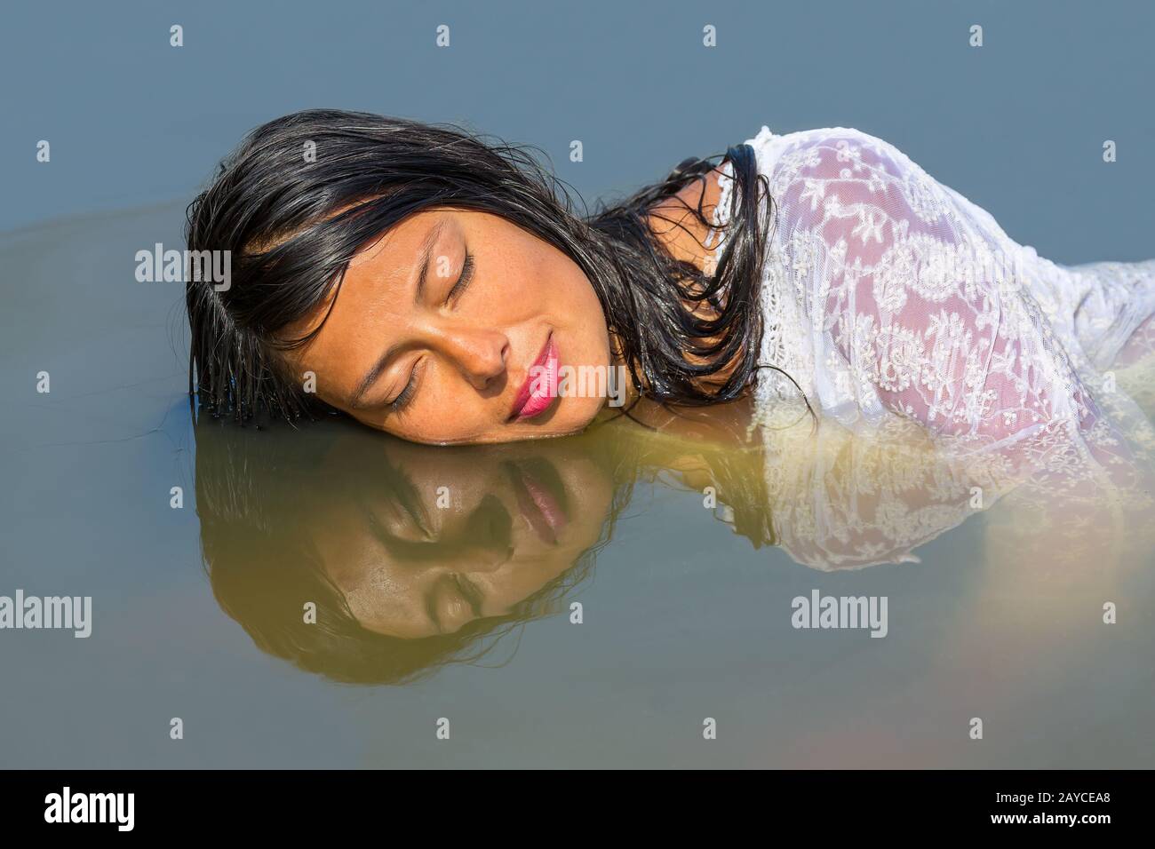Weibliche Gesichtsreflexion im Hochformat in Wasser Stockfoto