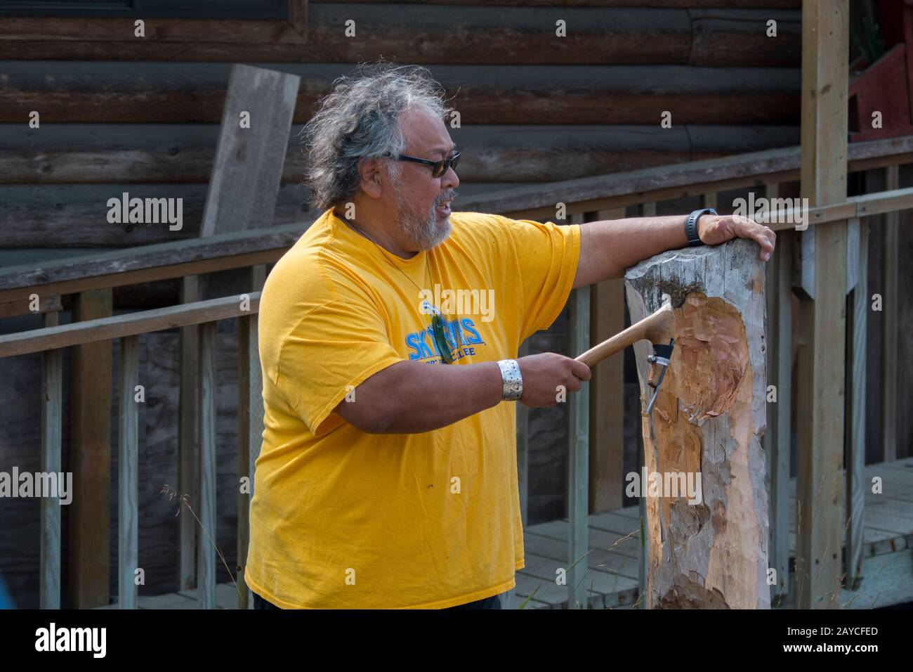 Der Holzschnitzer Michael Jackson (Haida) erklärt die Schnitzerei eines Totempfahls im Dorf Kake, einem Tlingit Dorf auf Kupreanof Island w Stockfoto