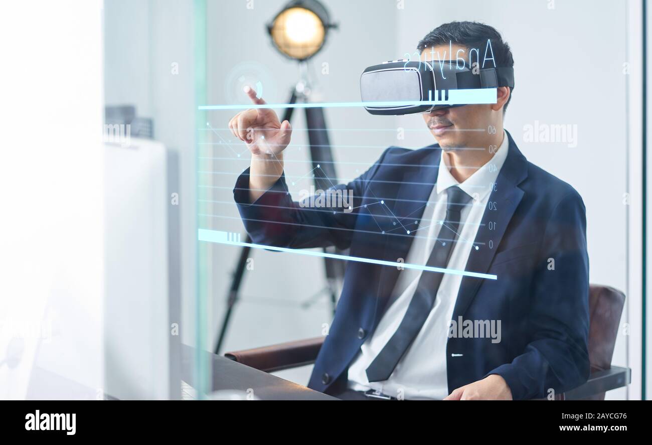 Asiatische Geschäftsleute, die eine virtuelle Reality-Brille tragen und die Wachstumskarte eines Unternehmens in einem Büro zeigen. Stockfoto