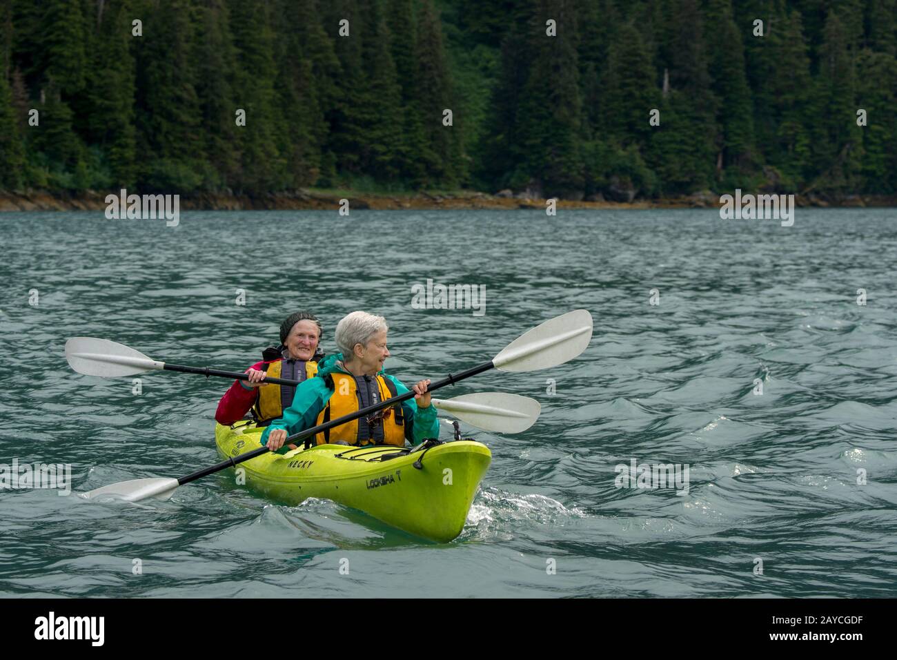 Frauen, die in der Takatz Bay auf Baranof Island, Tongass National Forest, Alaska, USA Kajakfahren. Stockfoto
