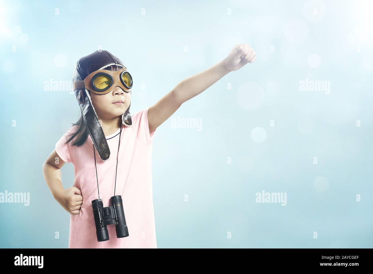 Kleine asiatische Mädchen tragen eine Flugzeugbrille und ein Teleskop Stockfoto