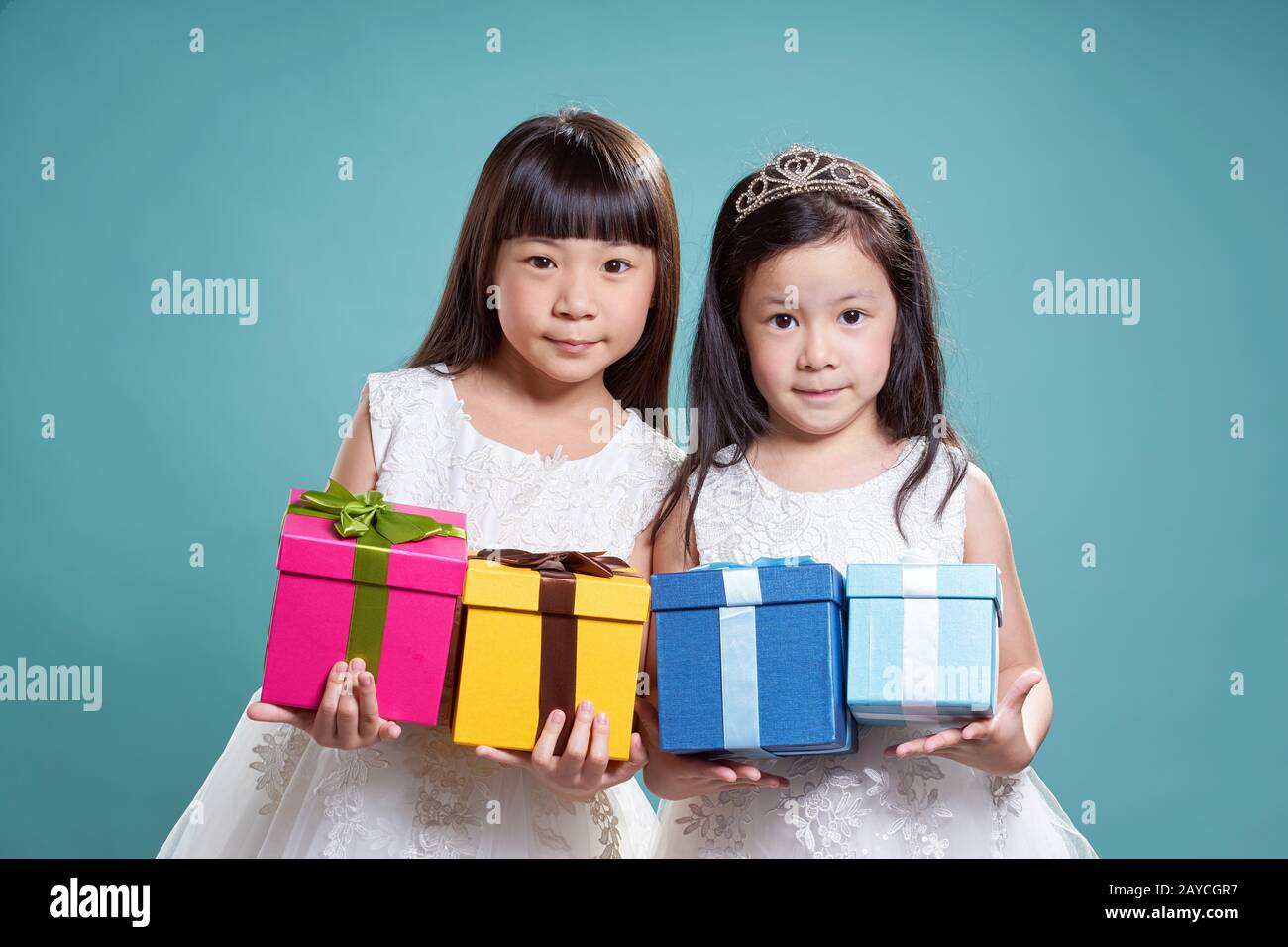 Portrait von zwei kleinen asiatischen schönes Mädchen vier vorliegenden Box auf Vintage blauen Hintergrund. Stockfoto