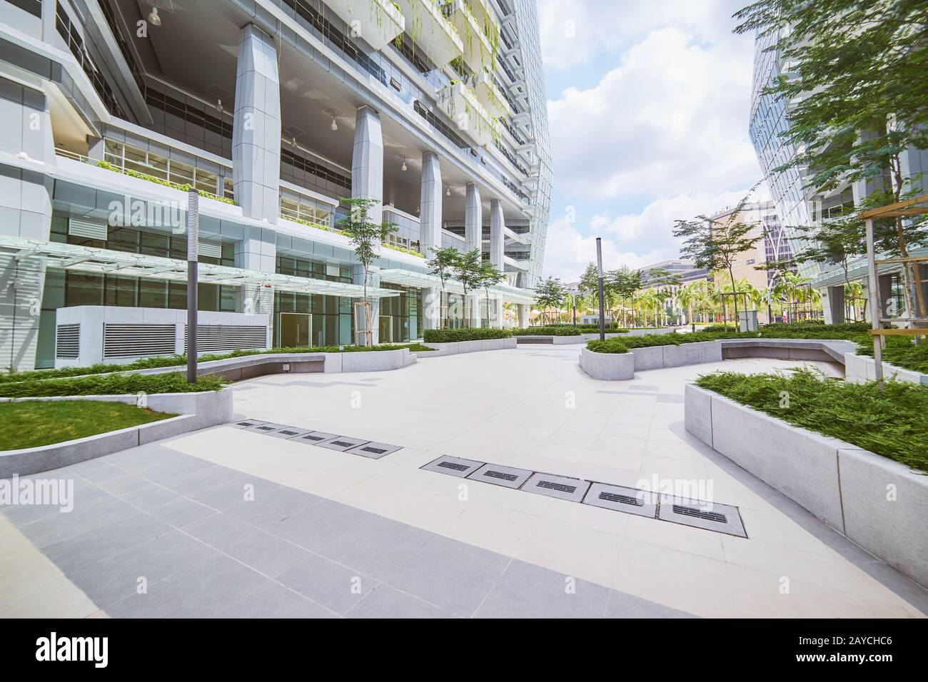 Schwachwinkeliger Blick auf das leere Straßenbelag und das moderne Bürogebäude mit umweltfreundlichem Konzept. Stockfoto