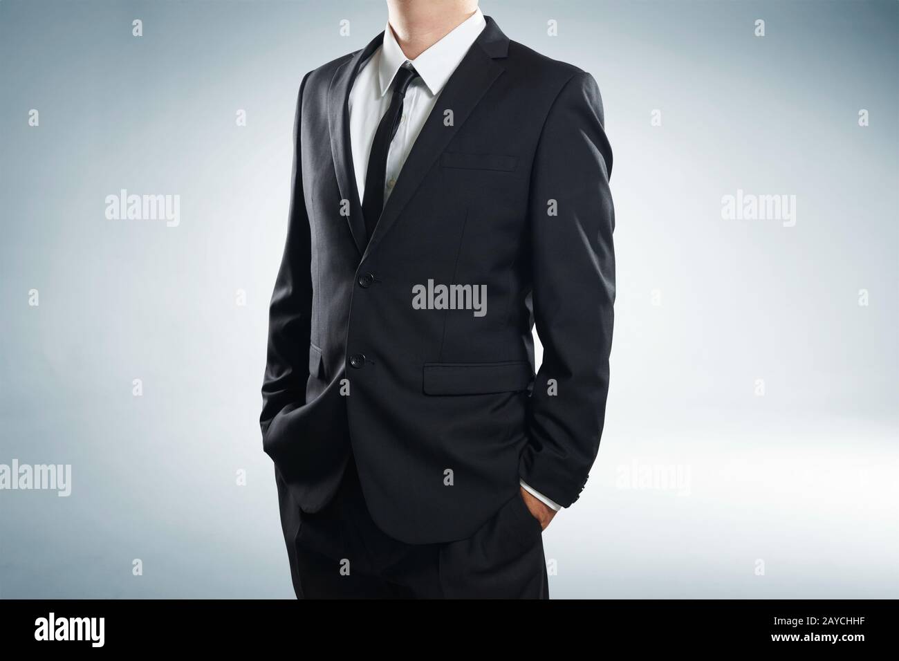 Nahaufnahme eines Teils des menschlichen Körpers in schwarzem Anzug mit Händen in Taschen auf weißem Hintergrund Stockfoto