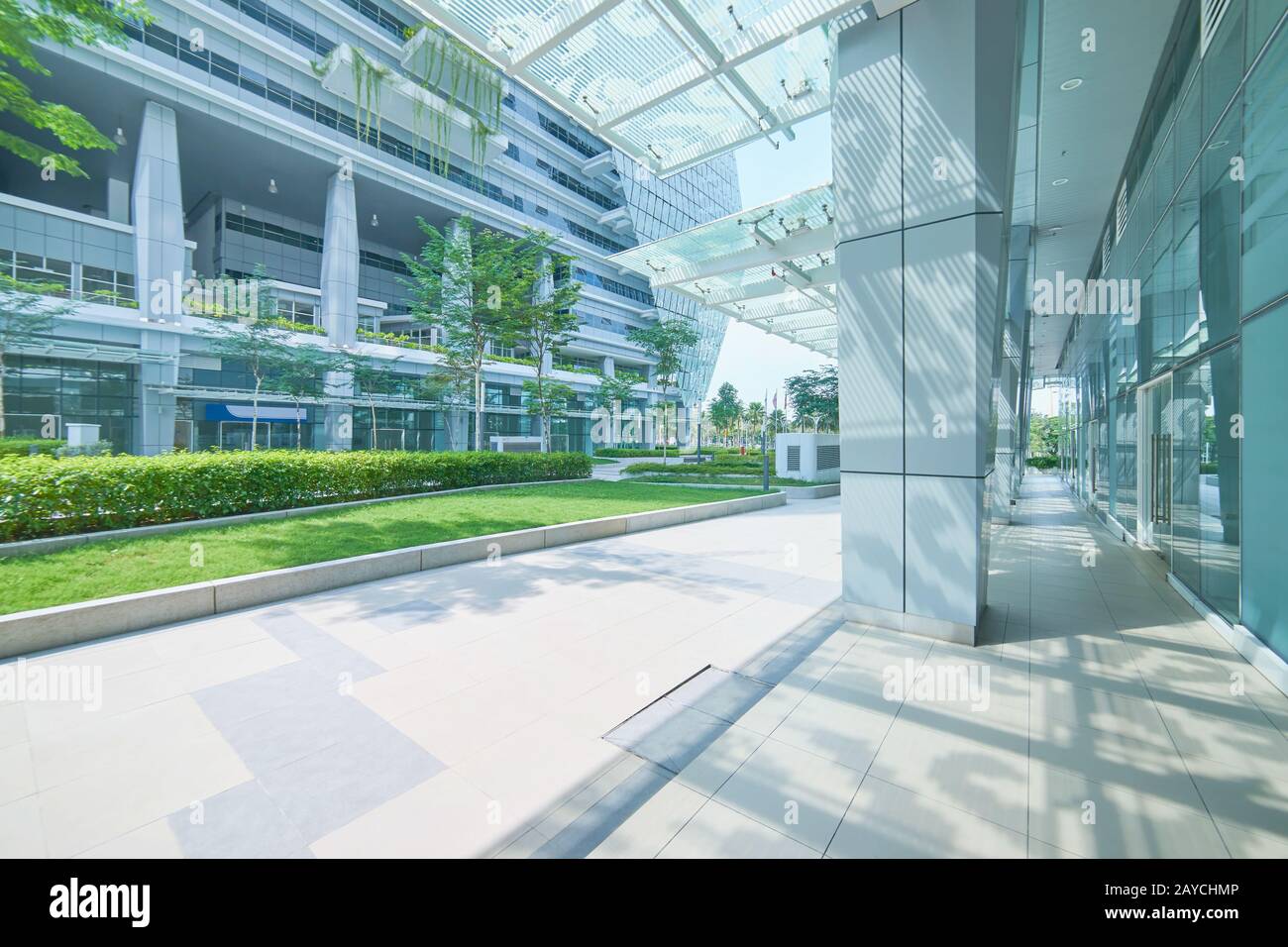 Außenansicht eines modernen Bürogebäudes aus Stahl und grünem Glas mit leerem Gehweg. Panoramaaussicht. Moderner Architekt Stockfoto