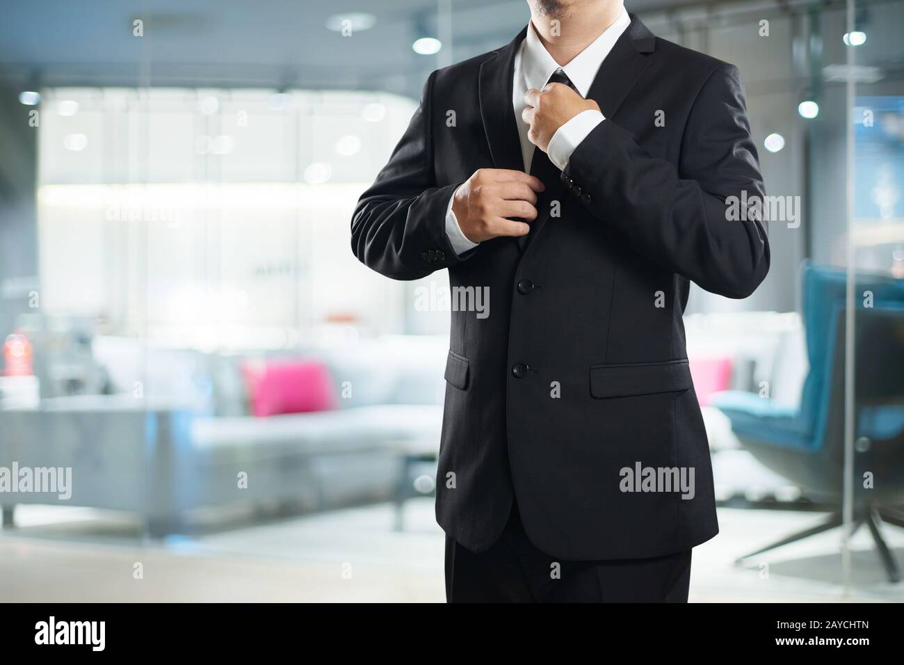 Intelligente Geschäftsmann im schwarzen Anzug mit Krawatte Pose anpassen Stockfoto