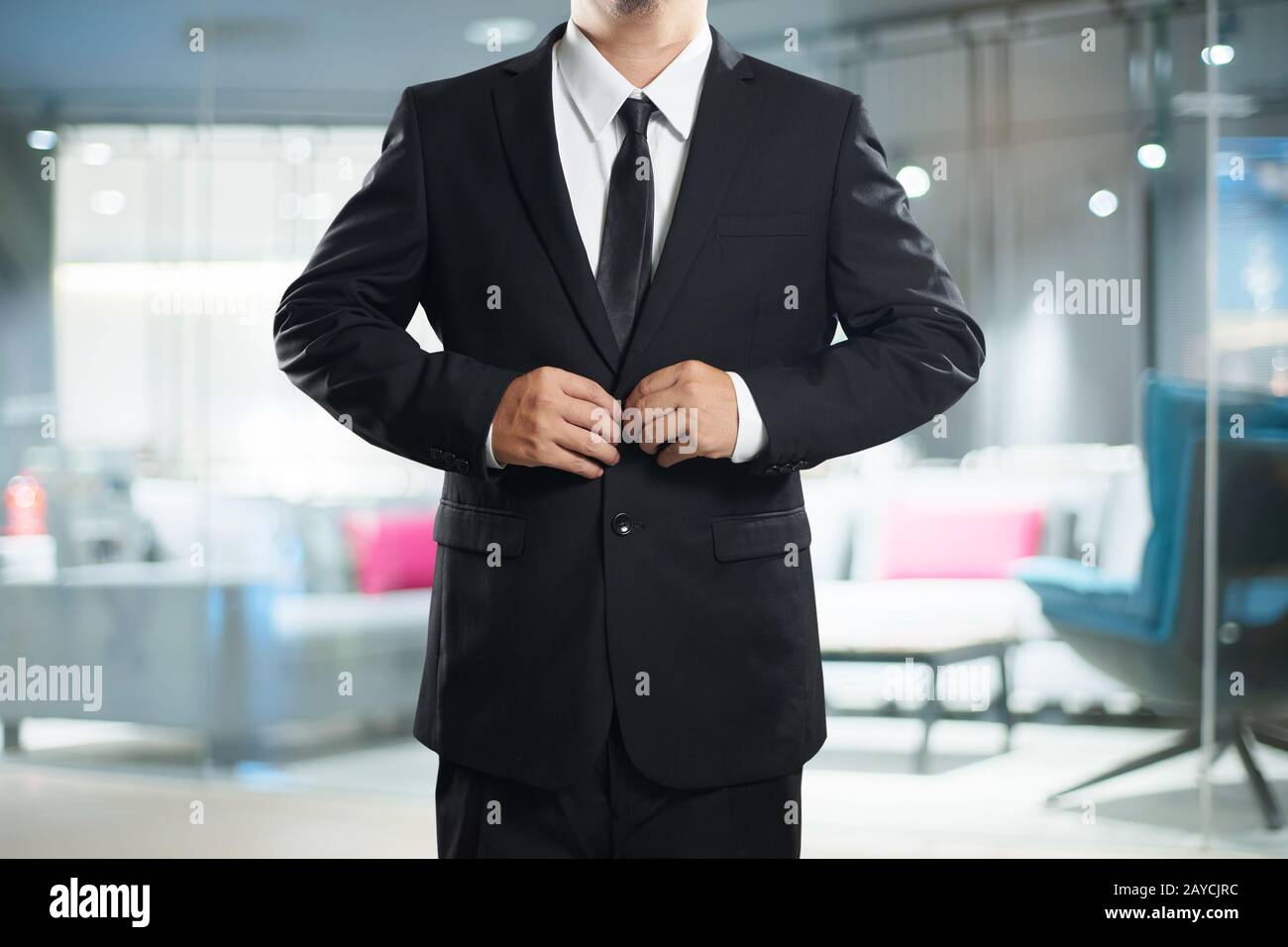 Intelligente Geschäftsmann im schwarzen Anzug mit Schaltfläche "Pose". Stockfoto
