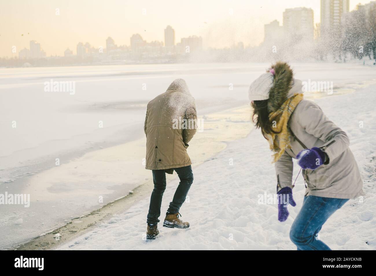 Junge kaukasische Menschen, die sich in heterosexuellen Paaren verliebt haben, haben im Winter ein Datum in der Nähe eines gefrorenen Sees. Aktivurlaub Valentinstag Stockfoto