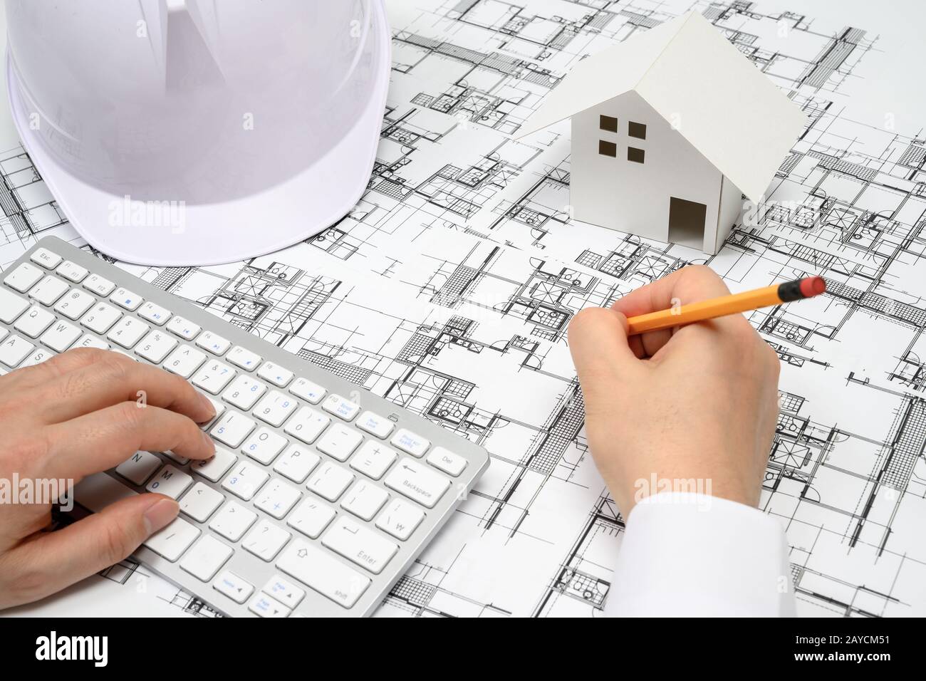 Ein Mann, der einen Bleistift in der Hand hält und Architekturzeichnungen malt. Stockfoto