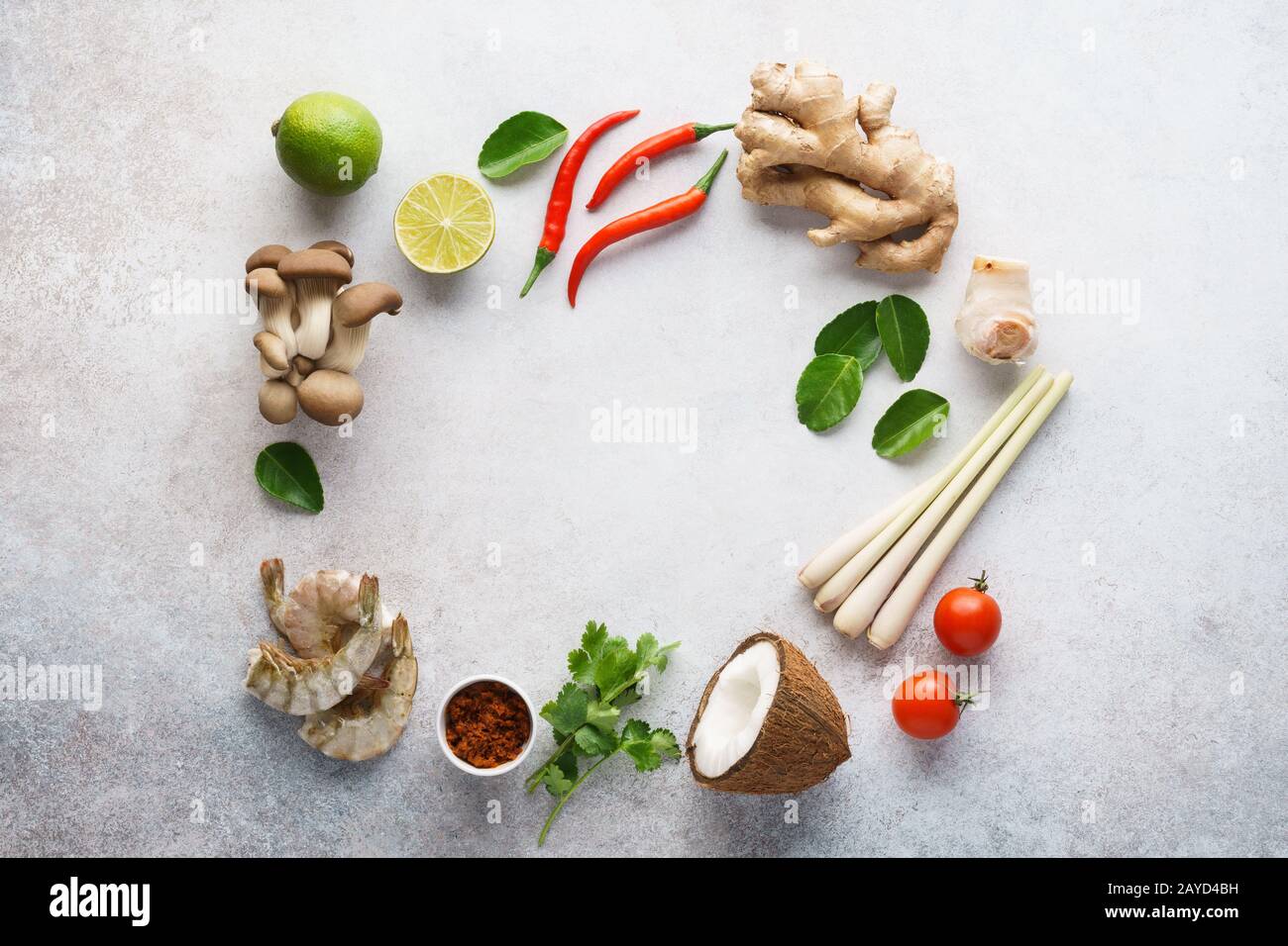 Rahmen aus verschiedenen Zutaten für die Zubereitung von Tom Yum - traditionelle würzige thailändische Suppe mit Pilzen, Garnelen oder Garnelen und Kokosmilch. Hintergrund mit Stockfoto