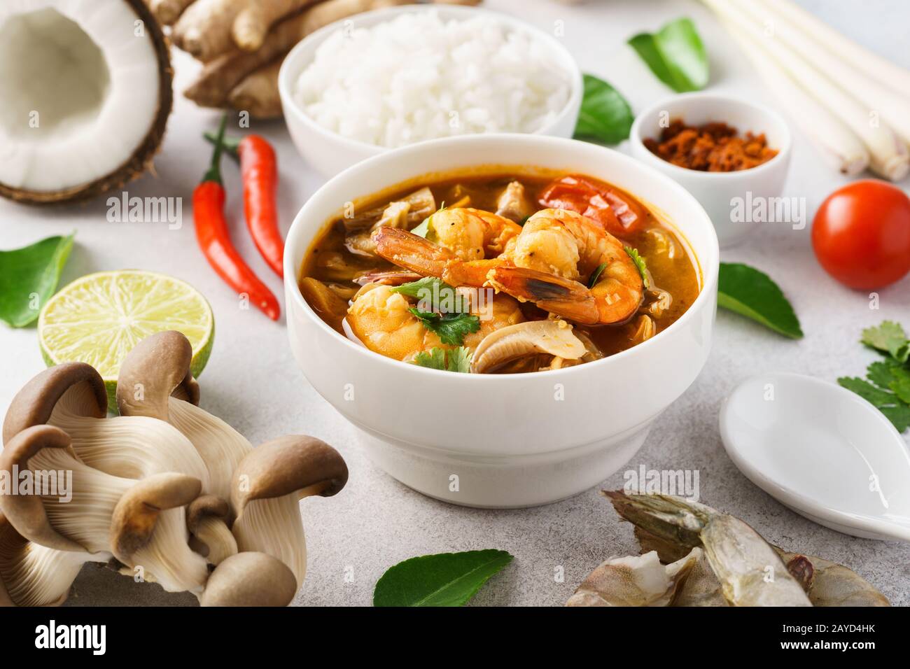 Traditionelle würzige thailändische Suppe Tom Yum Goong oder Tom Yum Kung und verschiedene Zutaten rund um. Serviert mit Reis. Stockfoto