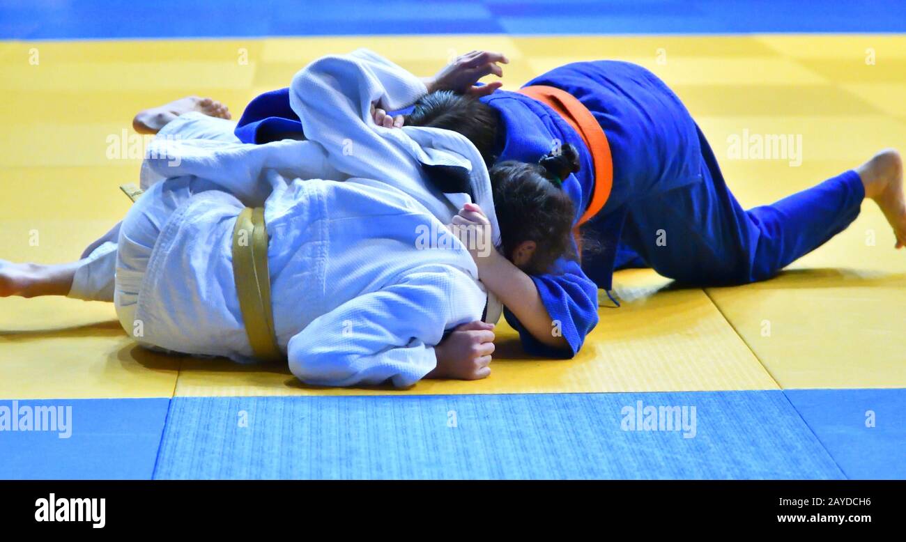 Zwei Mädchen judoka im Kimono konkurrieren auf dem Tatami