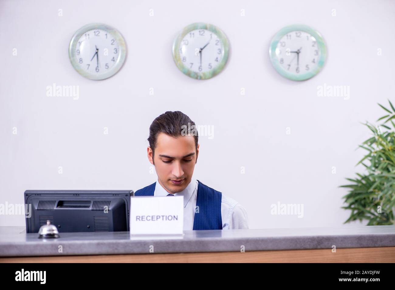 Junge Mann an der Rezeption im Hotel Zähler Stockfoto