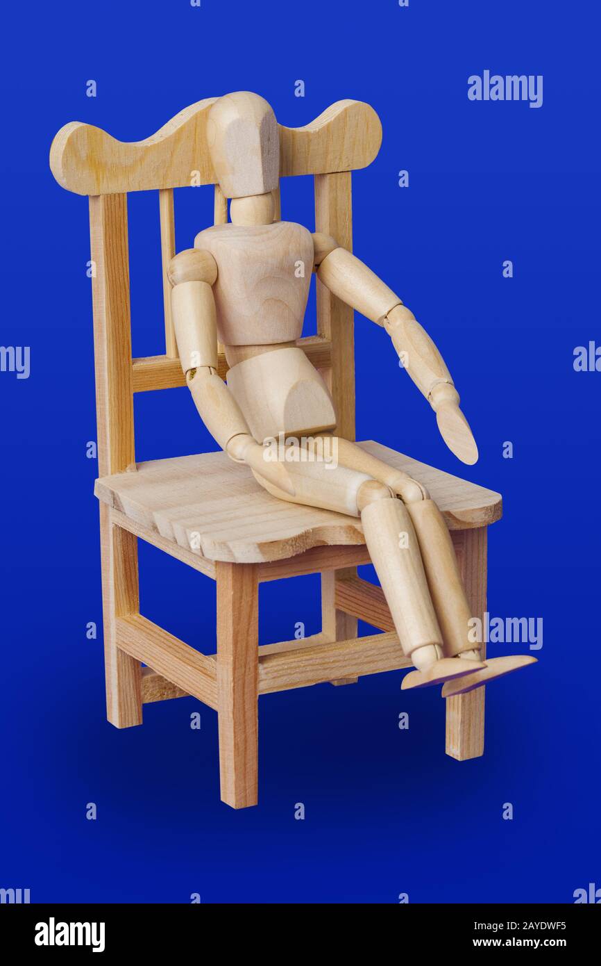 Spielzeugfigur aus Holz auf dem Stuhl - blau Stockfoto