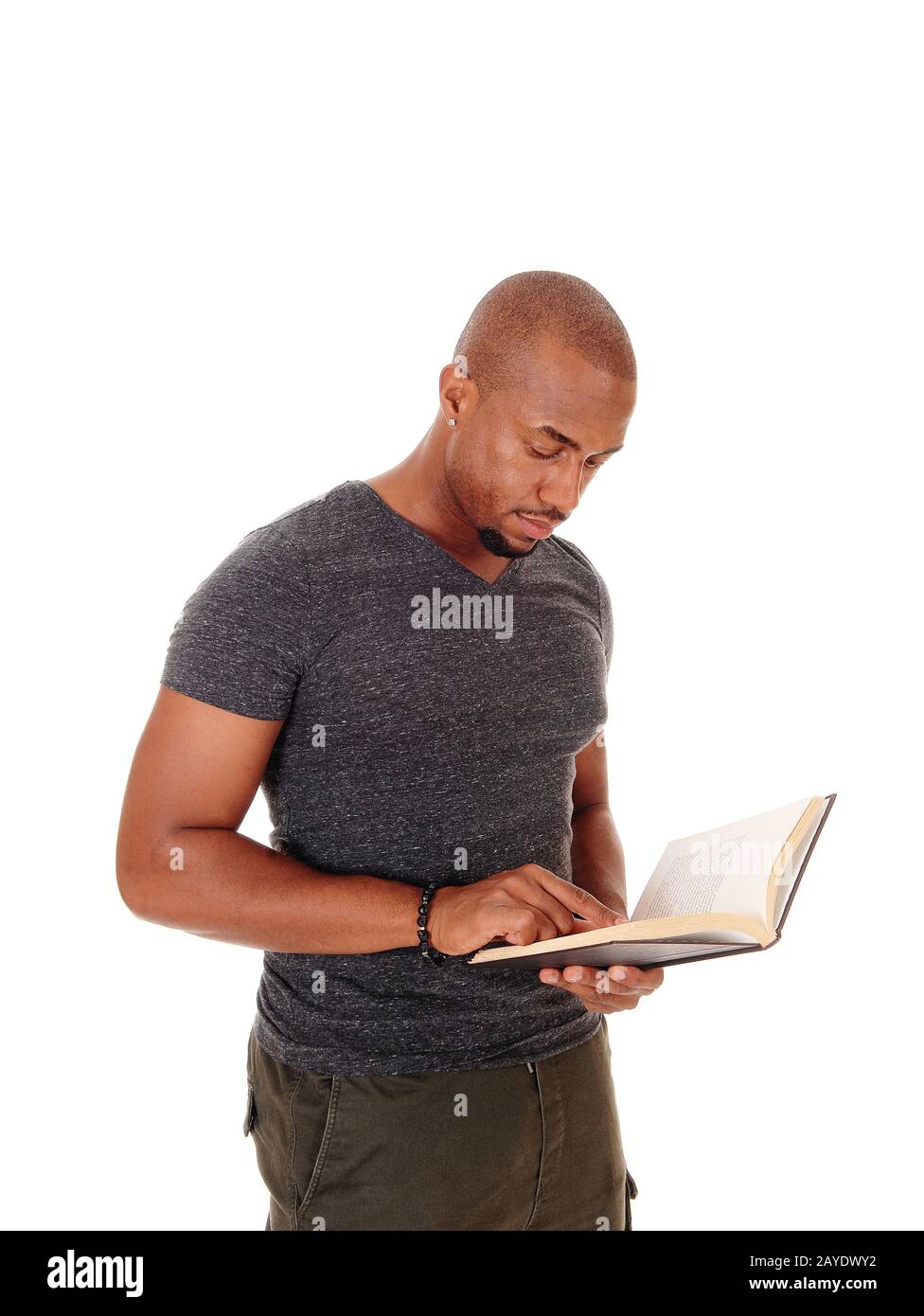 Afrikanischer Mann steht und liest in seinem Buch Stockfoto