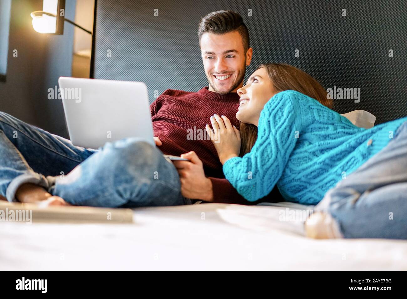Glücklicher Freund und Freundin kaufen online mit Laptop Computer - Junge Leute haben Spaß beim Kauf von Geschenke im Internet zu Hause - Urlaub und Stockfoto