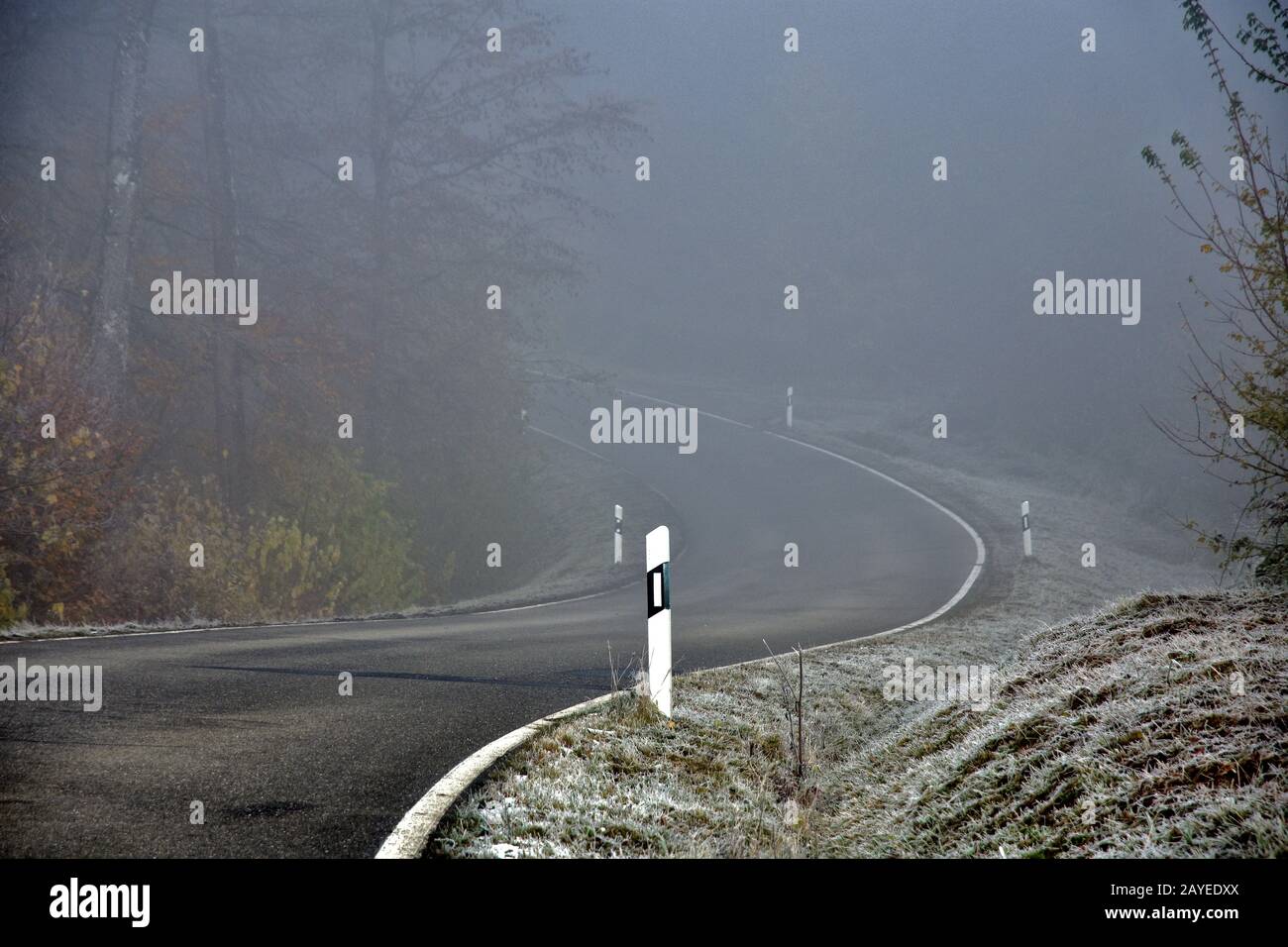 Unfallgefahr durch vereiste Straßen und Nebel auf kurvenreichen Straßen Stockfoto